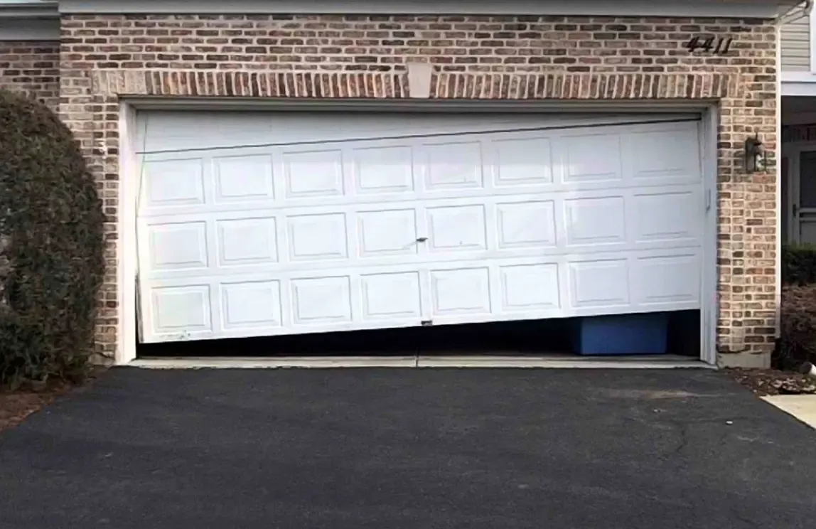 Damaged garage door off track requiring emergency repair service