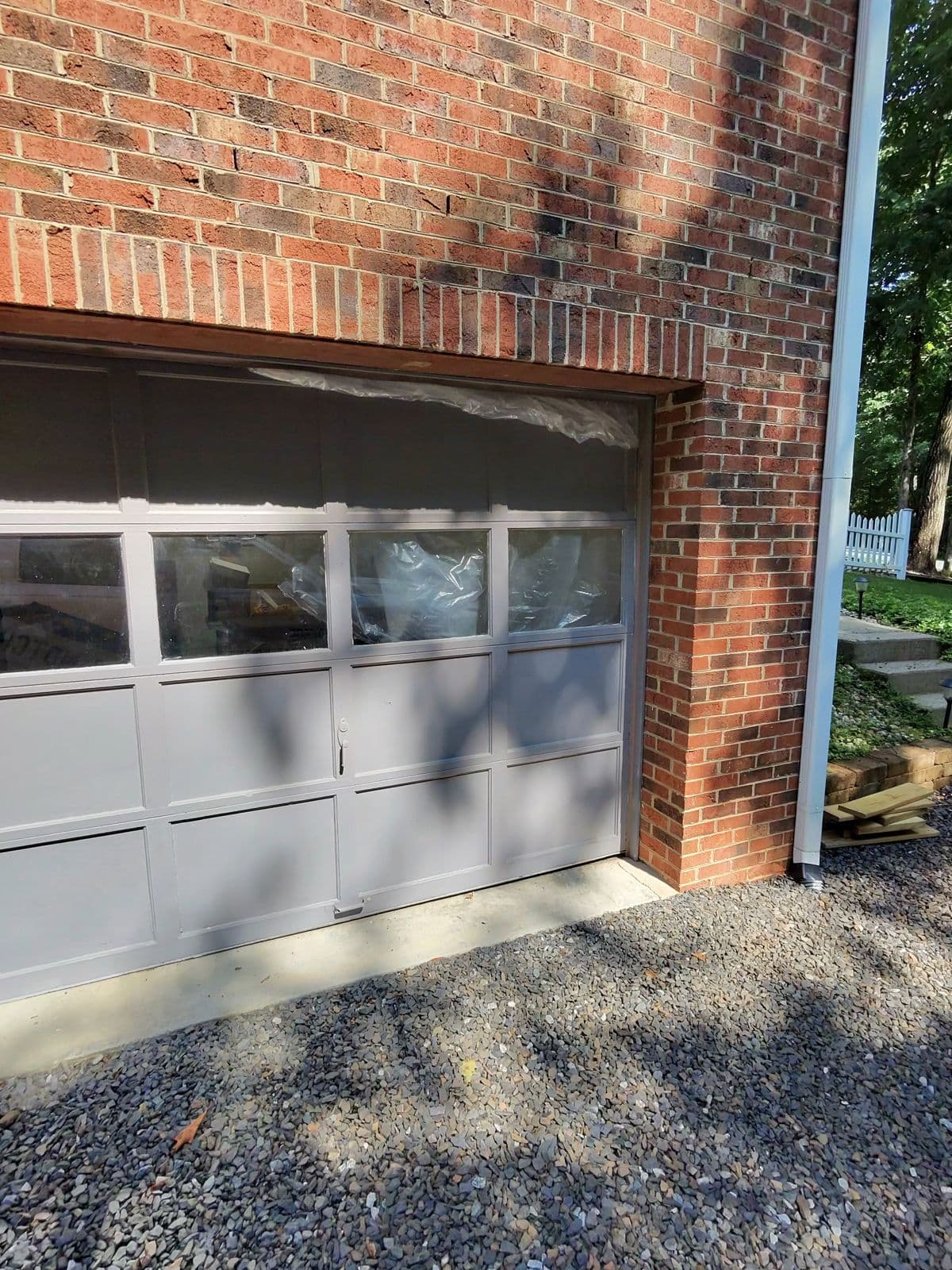 Old blue-gray garage door before replacement on brick home in Thomasville NC
